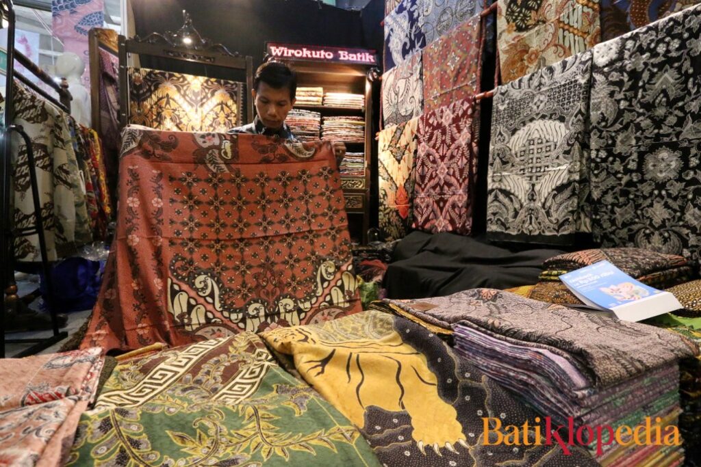 Penjual Batik Wirakuto sedang membentangkan batik untuk pembelinya