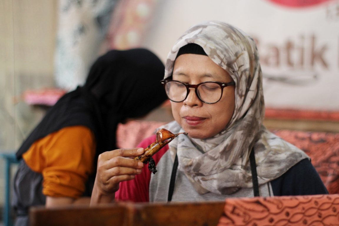 Rukoyah sedang mencanting kain batiknya