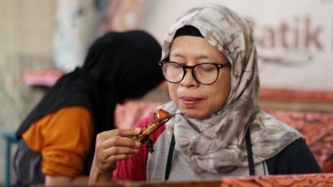 Rukoyah sedang mencanting kain batiknya