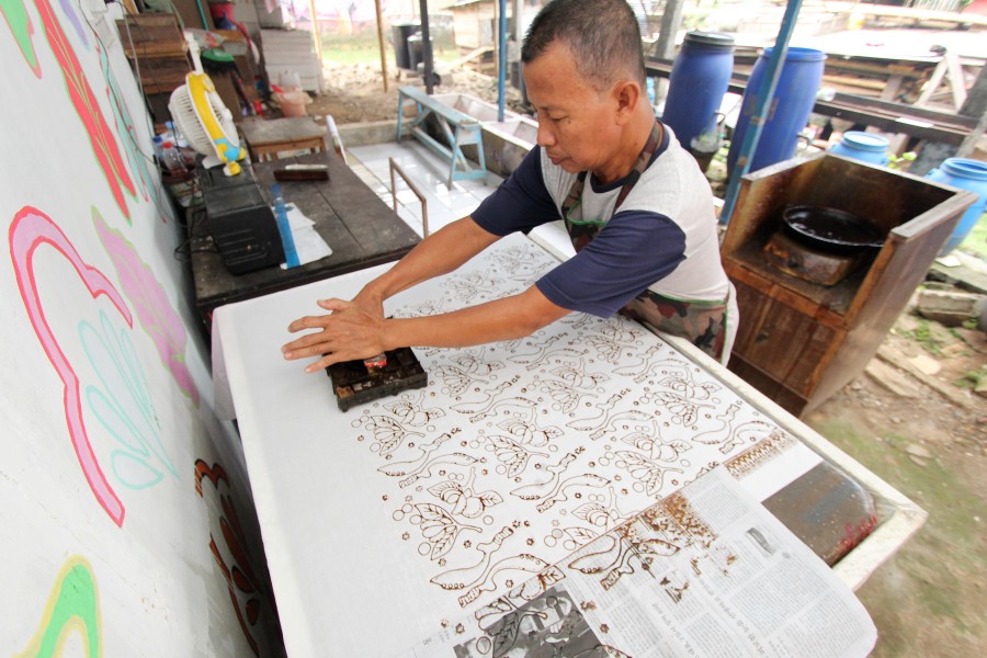 Ipoenk Ngadianto tengah memproses batik cap