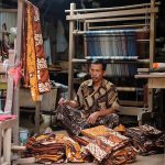Ilustrasi perajin batik tulis dengan barang dagangannya yang masih menumpuk akibat kontraksi pasar yang melemah.