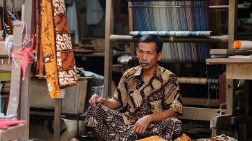 Ilustrasi perajin batik tulis dengan barang dagangannya yang masih menumpuk akibat kontraksi pasar yang melemah.