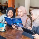 Para anak muda sedang menghadiri peluncuran Kampung Batik AI di Bandung. Mereka diberikan pemahaman tentang cara membuat desain batik menggunakan aplikasi AI