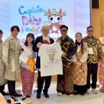 Direktur Kreatif Jember Fashion Carnival (JFC) sekaligus Penata Rias Bubah Alfian (kelima dari kanan) memberikan suvenir berupa kaus oblong bergambar kucing ikonik Presiden Prabowo Subianto, “Kapten Bobby,” kepada pelukis kontemporer Jepang Inoue Bunta (kelima dari kiri), didampingi para pendiri Yayasan Sakuranesia Sakura Ijuin (keempat dari kanan) dan Tovic Rustam (ketiga dari kanan), usai dialog budaya di Expo Osaka 2025, Paviliun Indonesia, Kansai, Jepang, Selasa (10 Juni 2025).