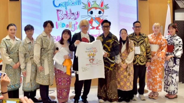 Direktur Kreatif Jember Fashion Carnival (JFC) sekaligus Penata Rias Bubah Alfian (kelima dari kanan) memberikan suvenir berupa kaus oblong bergambar kucing ikonik Presiden Prabowo Subianto, “Kapten Bobby,” kepada pelukis kontemporer Jepang Inoue Bunta (kelima dari kiri), didampingi para pendiri Yayasan Sakuranesia Sakura Ijuin (keempat dari kanan) dan Tovic Rustam (ketiga dari kanan), usai dialog budaya di Expo Osaka 2025, Paviliun Indonesia, Kansai, Jepang, Selasa (10 Juni 2025).