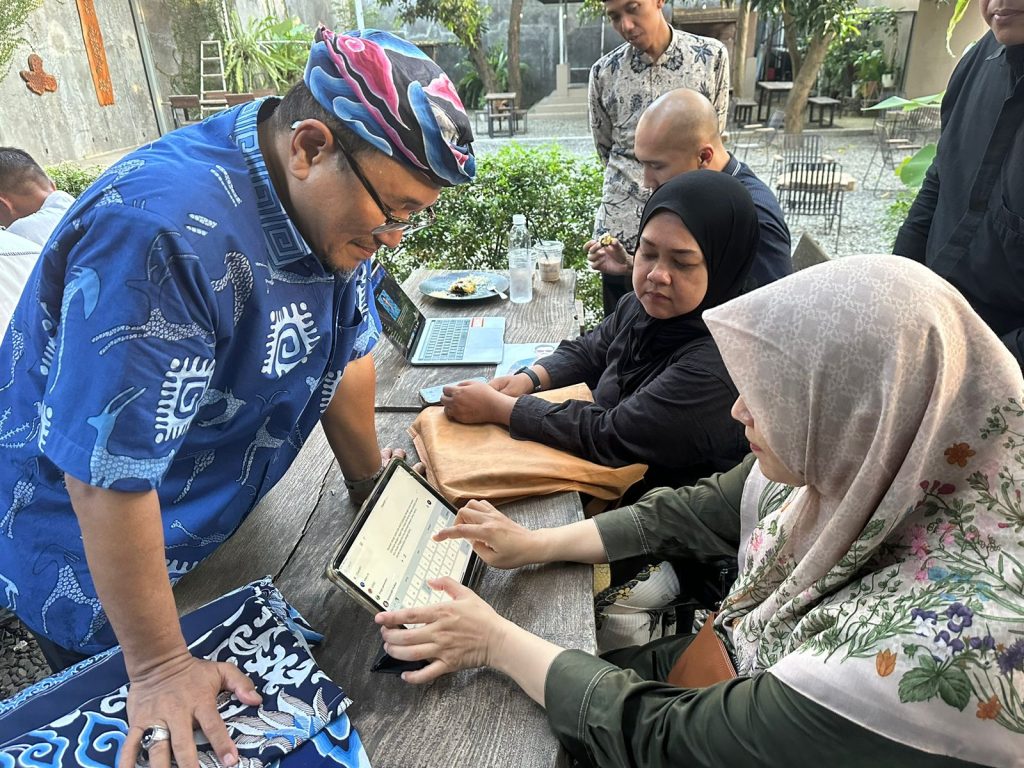 Komarudin Kudiya sedang memperhatikan tutorial desain batik AI