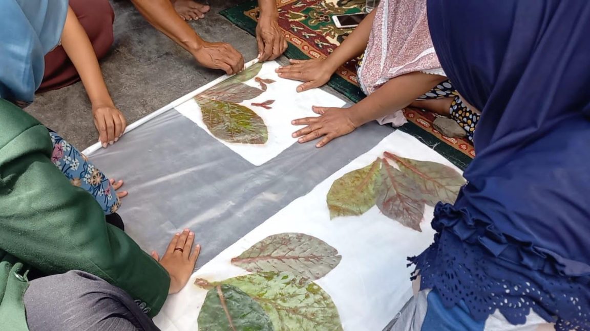 Batik daun jati dimanfaatkan sebagai sumber warna dan motif selendang melalui teknik batik tulis dan ecoprint dengan pewarna alam sekitar.