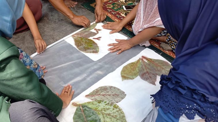 Batik daun jati dimanfaatkan sebagai sumber warna dan motif selendang melalui teknik batik tulis dan ecoprint dengan pewarna alam sekitar.