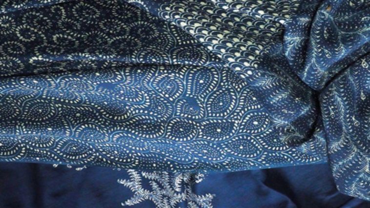 Teknik batik indigo menggunakan daun Indigofera tinctoria melalui fermentasi, reduksi, pencelupan dan pelorodan untuk menghasilkan warna biru.
