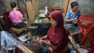 Motif Batik Sukoharjo jamu gendhong memadukan figur mbok jamu, rempah, buketan, kembangan, dan isen-isen dengan warna sogan klasik setempat.