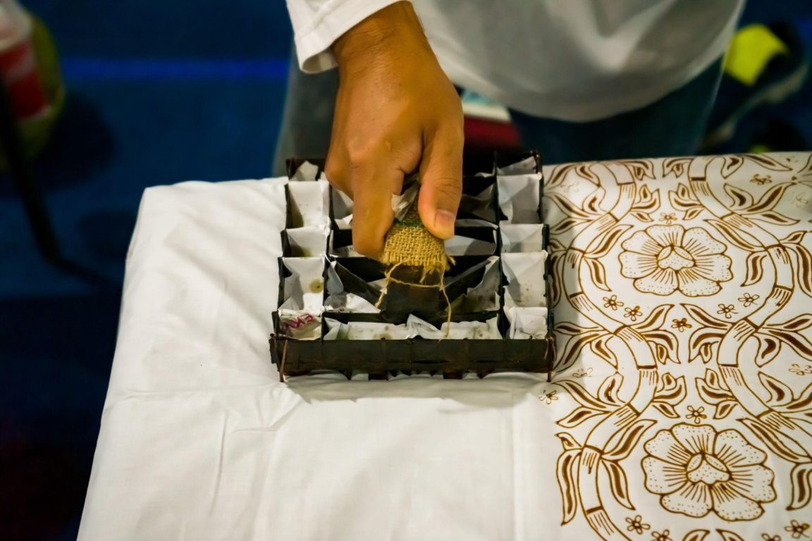 Sablon batik dikombinasikan dengan teknik cap menggunakan balok kayu untuk menghasilkan motif kontemporer pada kain produk fashion modern.