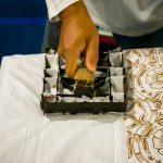 Sablon batik dikombinasikan dengan teknik cap menggunakan balok kayu untuk menghasilkan motif kontemporer pada kain produk fashion modern.