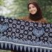 Buat gambar ukuran 1920 x 1080 piksel (landscape): Perempuan cantik Indonesia sedang membentangkan motif batik Kamis Legi